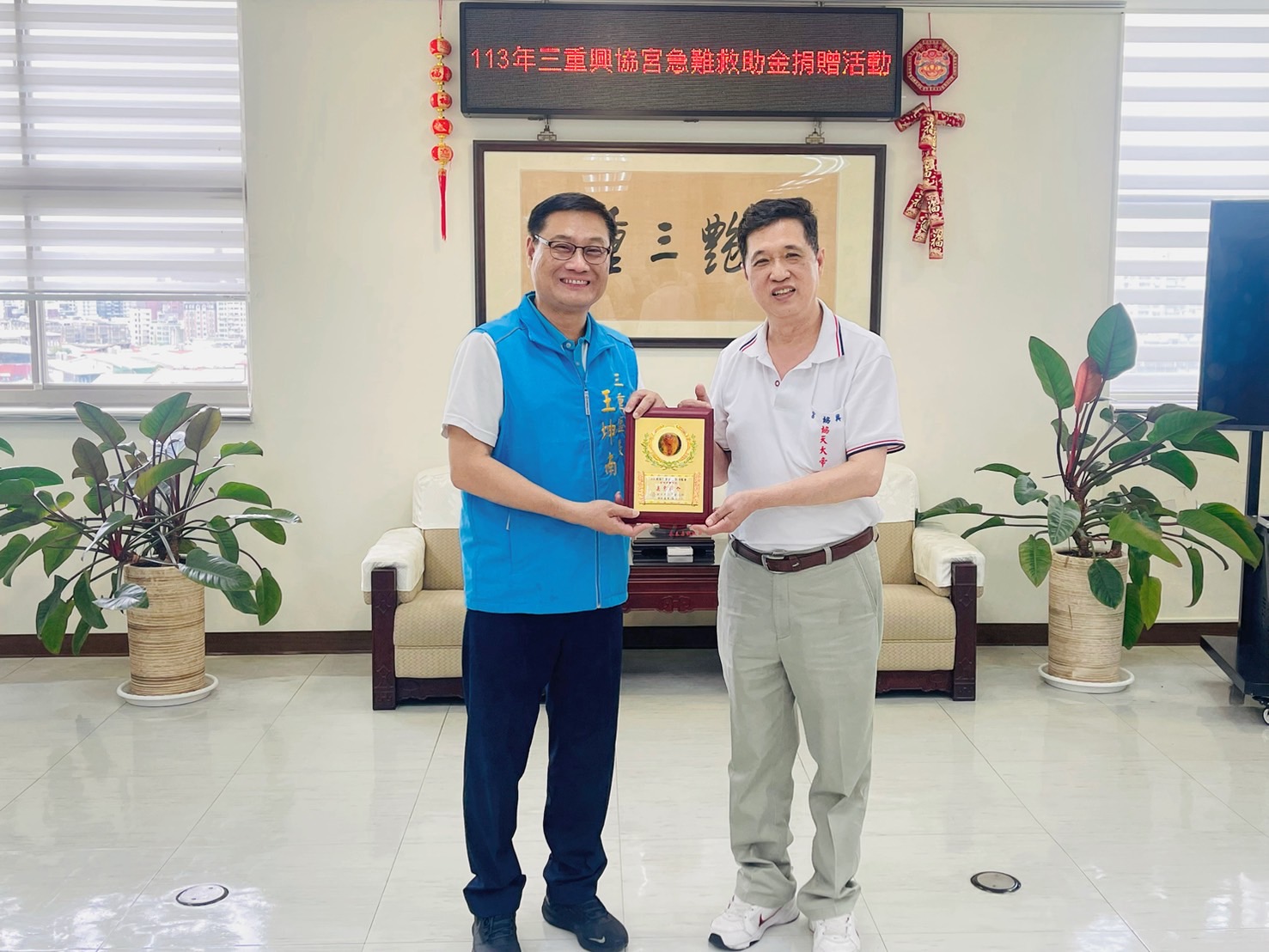 三重王坤南區長(左)致贈感謝狀予三重興協宮聖光普濟功德會林金闕會長(右)，感謝興協宮善心義舉。