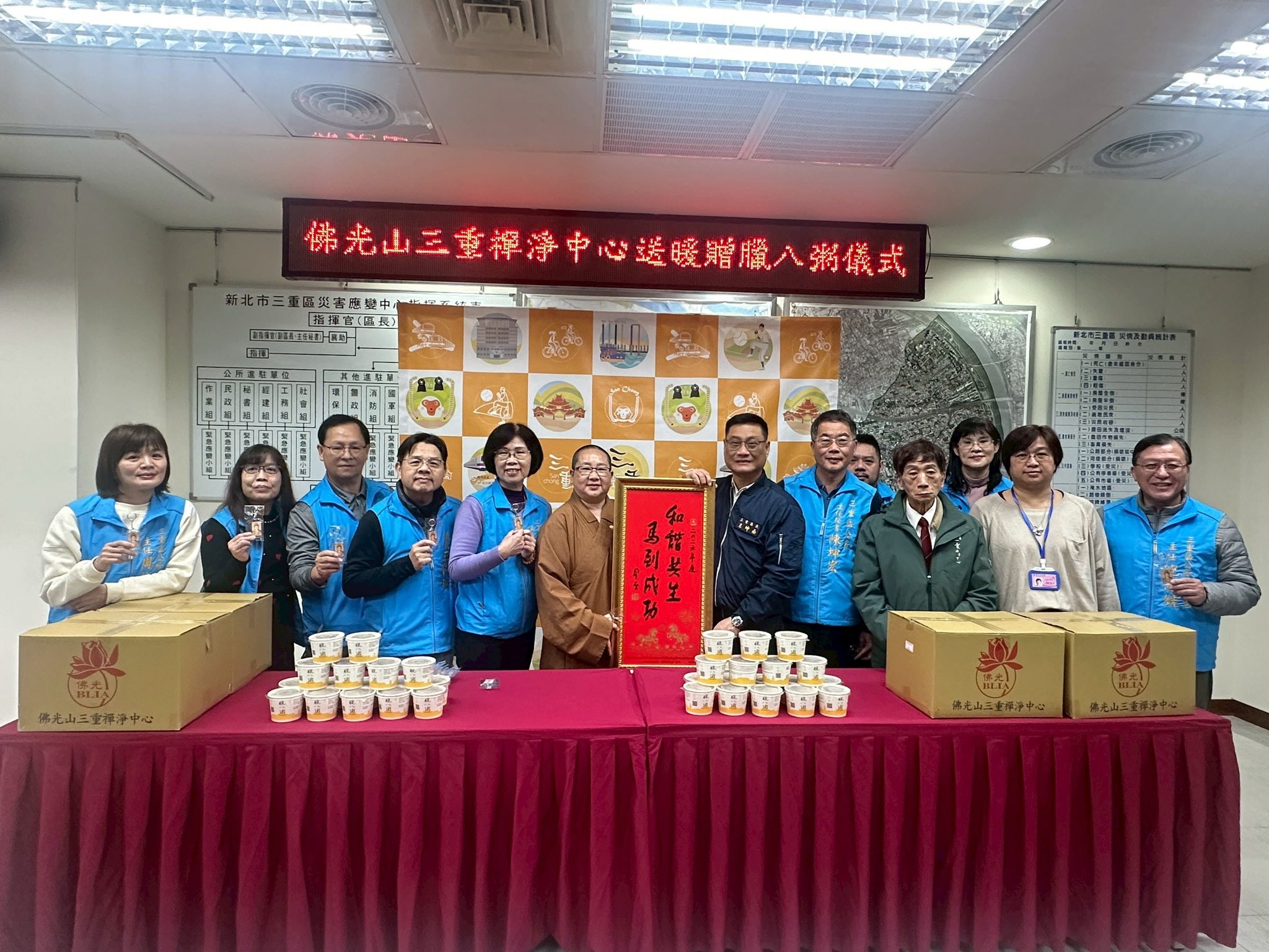 佛光山三重禪淨中心如宗法師(左)暖心贈500份臘八粥予三重區單位，由三重區長王坤南(右一)代表受贈。